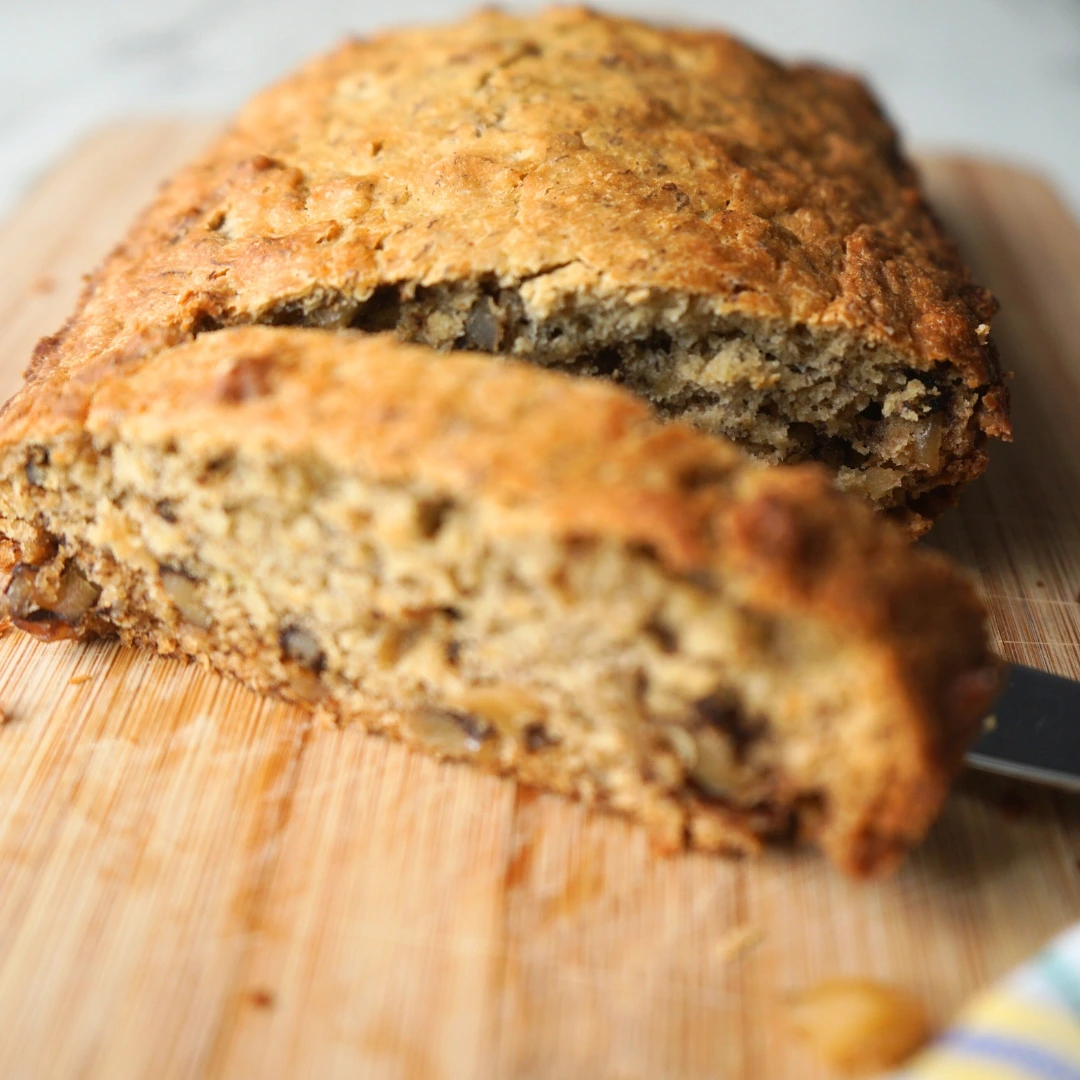 A sliced loaf of banana bread on a cutting board