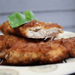 Chicken Cutlets on a plate with a basil leaf on top